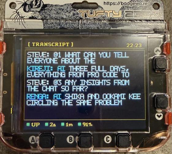 The badge showing its transcript screen: Steve asking the cast
                  about the conference, Kireji answering, and Renga summarising
                  what two guests have been circling.